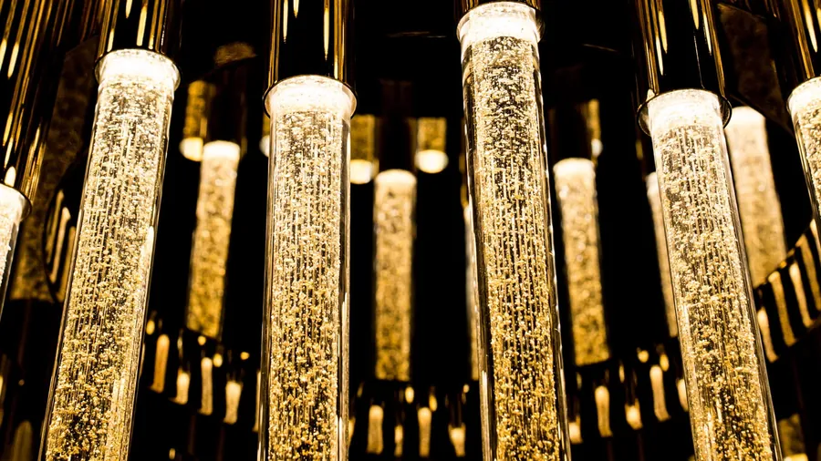 Cascata New York: tubi in vetro con bollicine su struttura in ottone dorato.