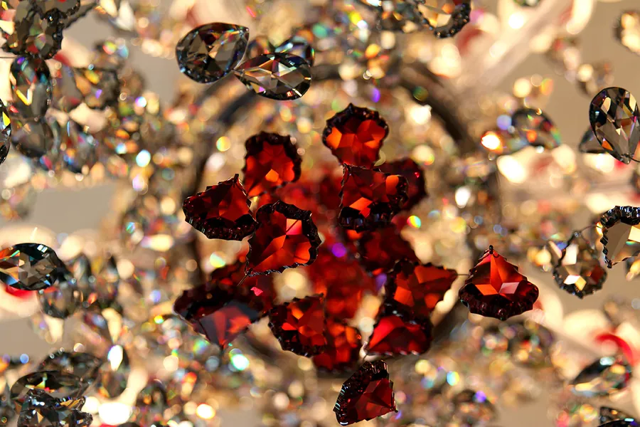 Macro di cristalli molati rossi e trasparenti che rifrangono la luce.