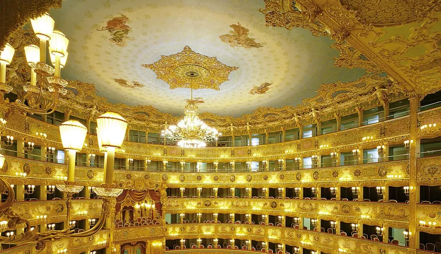 Sala del Teatro La Fenice illuminata dal lampadario centrale in cristallo.